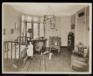 Een meisje dat een kaars vasthoudt, klimt in een wieg, in een slaapkamer van de A.C. Cronin residentie, 1915-16